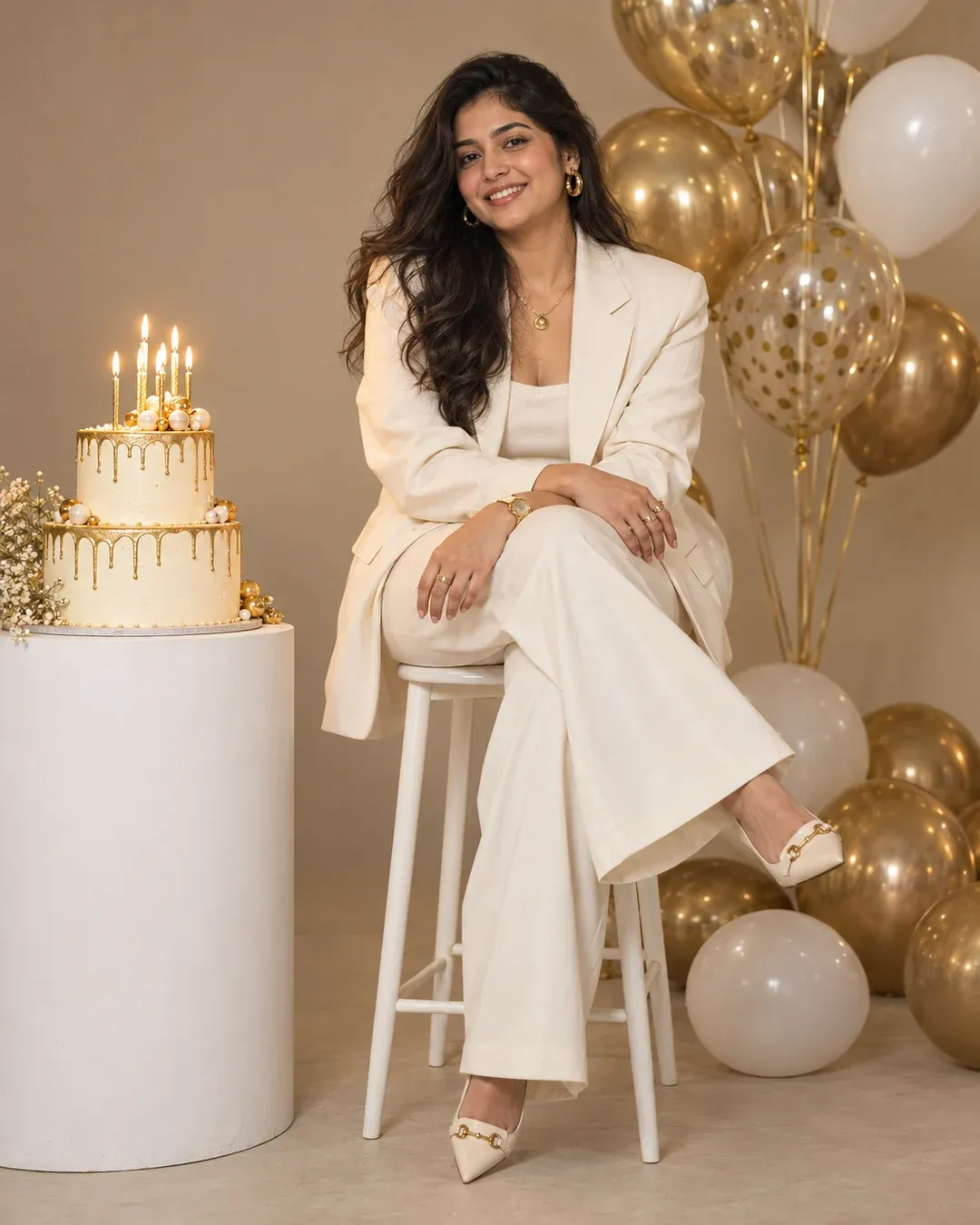 Example result: A stylish birthday portrait in an oversized cream blazer, seated on a chair beside a cake with lit candles and gold and white balloons.