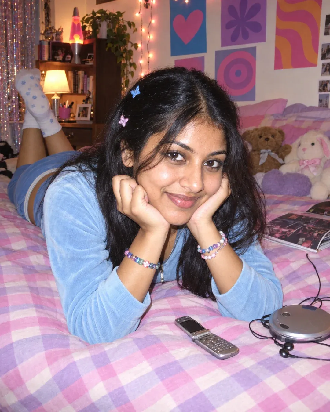Example result: A 2000s-style flash snapshot of a person lying on a bed in a Y2K teen bedroom with fairy lights and a flip phone.